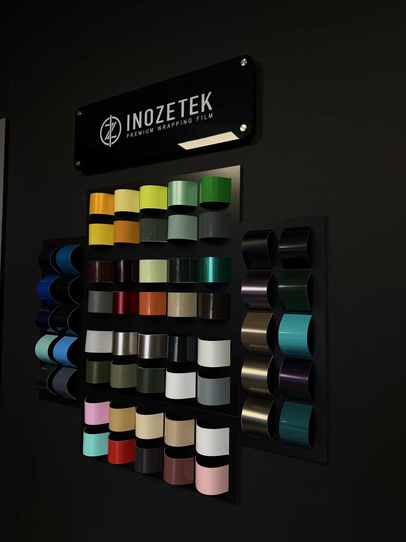 The film sample wall in the Cloak lobby, rows of wrap colors under the Inozetek sign.
